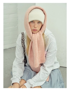 Detail of pink knitted hood scarf and white ribbed beanie set with soft wool blend texture