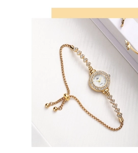 Detail of gold women's watch with rhinestone bezel and adjustable slider chain