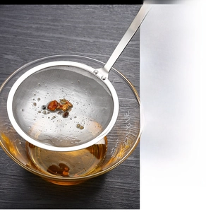 Close-up of the 304 stainless steel fine mesh strainer resting on a glass bowl
