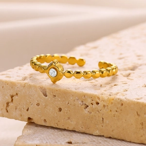 Detail of 18k gold irregular bead ring with a sparkling clear zircon stone