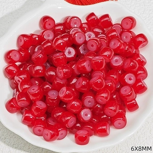 Detail view of red 6x8mm glass beads in a shell plate for DIY jewelry making