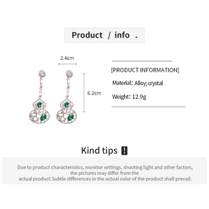 Détails des boucles d'oreilles évidées en forme de gourde avec cristaux verts et alliage