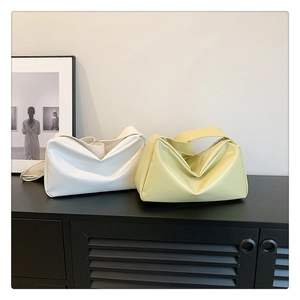Minimalist soft leather tote bags in white and yellow shown on a stylish indoor side cabinet
