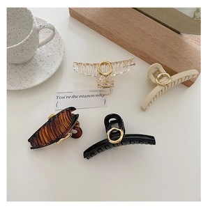 French style hair claws in transparent, beige, tortoiseshell, and black with gold ring accents