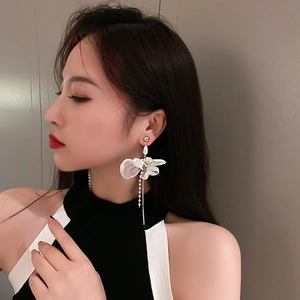 Elegant white fabric flower tassel earrings with pearls and gold chains on model