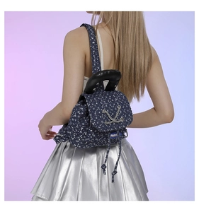 Detail of dark blue floral denim backpack with silver chain and black top handle