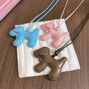 Détail de pendentifs chiots mignons en rose, bleu et marron avec détails de couture