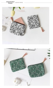 Detail view of retro paisley canvas coin purses in black and green with tassel zippers