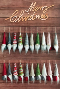 Detailed view of handmade Christmas gnomes with knit hats on a rustic wood backdrop