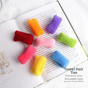 Macro detail of eight colorful towel scrunchies on book pages for children's hairstyles