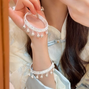 Gros plan détaillé des glands de cloche en argent et de l'enroulement sur le bracelet