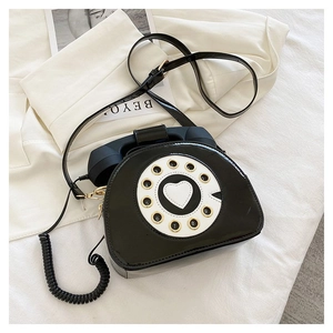 Detail of vintage telephone crossbody bag with black patent leather and a retro dial