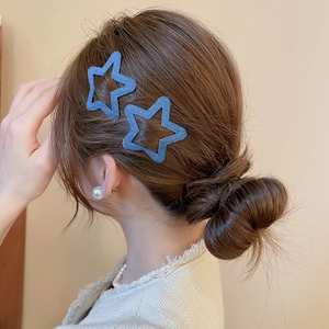 Close-up of star-shaped blue denim fabric hair clips worn on side of model's hair