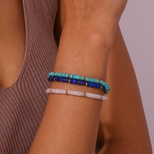 Macro detail of natural stone beaded bracelets in blue and pink with gold spacers