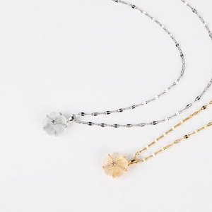 Detailed close-up of cherry blossom flower pendants in silver and gold finishes