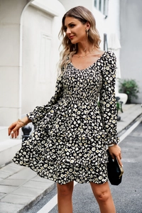 Detail of floral V-neck dress with smocked bodice and tiered ruffle skirt in black