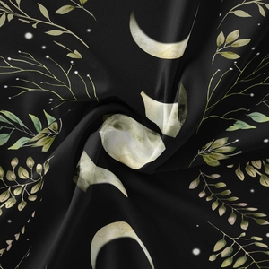 Close-up of silky black moon phase and botanical tapestry fabric with smooth texture