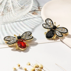 Detail of cute bee brooches featuring red and black gemstones with sparkling zircons