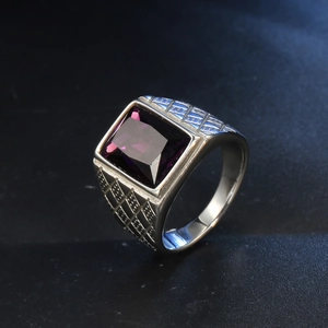 Detail of a vintage silver ring featuring a large rectangular purple gemstone and textured grid