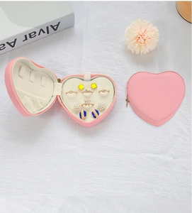 Detailed view of pink heart-shaped PU jewelry box with internal ring slots and soft lining