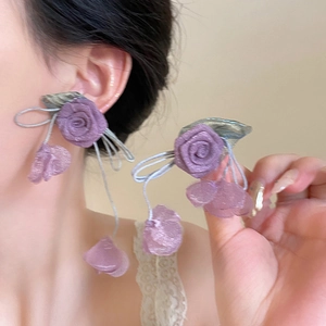 Detail of purple fabric rose earrings with silver leaf accents and long elegant tassels
