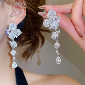Close-up of sparkling zircon flower and leaf tassel earrings with luxurious silver finish