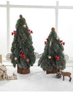 Close-up of mini snow-flocked Christmas trees with red berries and wood base