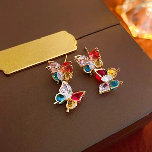 Macro shot of colorful zircon butterfly earrings with fine gold plating and claw setting