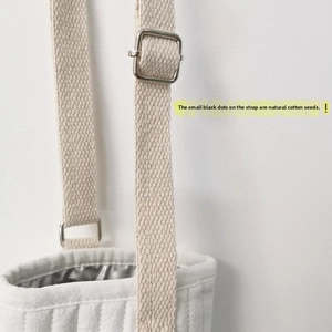 Detail of adjustable cotton shoulder strap and metal buckle on quilted water bottle bag