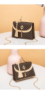 Detail view of vintage printed handbag with golden crown hardware and tassel accent