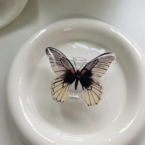 Macro view of butterfly phone grip with white resin finish and realistic black vein detail