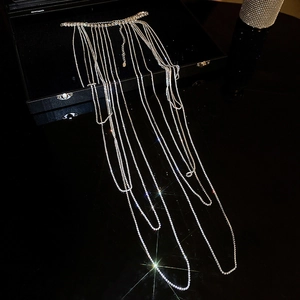 Macro shot of silver rhinestone body chain with layered tassels on black jewelry box