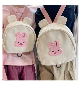 Kids beige canvas backpack with bunny patch and cute ears shown on toddlers