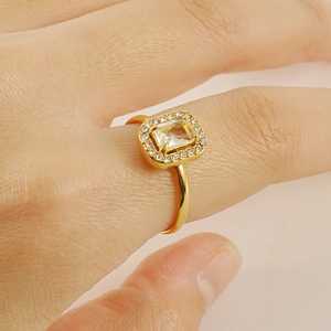Detailed close-up of a 18K gold-plated ring with a square zircon and diamond halo design