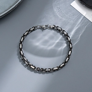 Macro detail of 8mm two-tone silver and black box chain bracelet with lobster clasp
