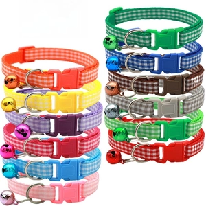 Close-up of colorful adjustable pet collars with bells and paw prints in various shades