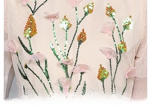 Close-up of pink mesh dress with sequin floral embroidery and 3D petal appliques