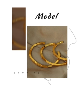 Detailed view of three minimalist gold-plated twisted open cuffs on beige silk background