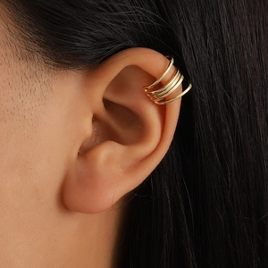 Detailed close-up of a layered gold ear cuff showing the polished metallic finish and U-shape
