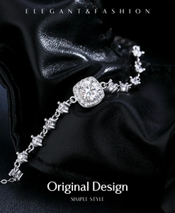 Macro detail of silver geometric bracelet featuring a square center stone on black leather