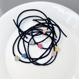 Assorted candy-colored matte heart hair ties in a minimalist white plate arrangement