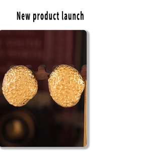 Macro shot of 18k gold plated stainless steel floral earrings with wrinkled texture