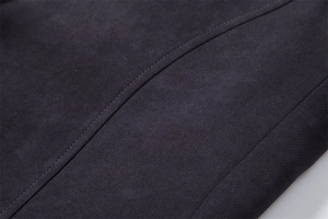 Macro view of woven dark gray wool fabric showing precise stitching and dense texture