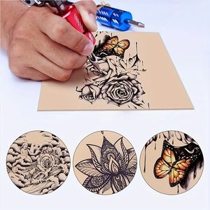 Close-up of tattoo pen on pink silicone practice skin with butterfly and rose designs