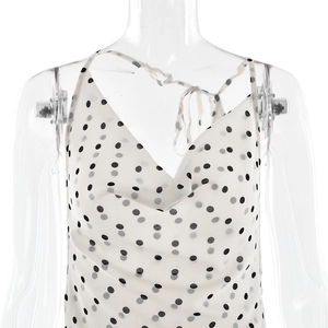 Detail of white sleeveless dress with black and grey polka dot pattern on light chiffon