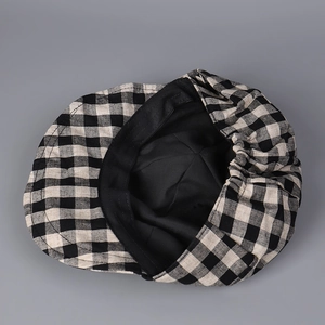 Internal detail of plaid beret showing black lining and elastic band closure