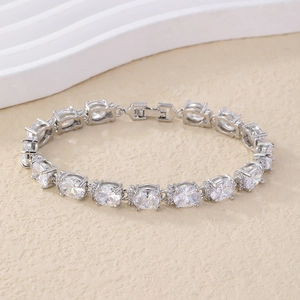 Silver-toned bracelet with oval cubic zirconia stones on textured beige surface