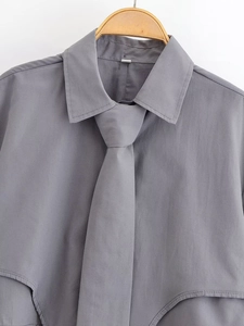 Detail of grey long-sleeved shirt with matching necktie and classic collar on hanger