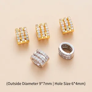 Detailed macro shot of gold and silver brass barrel beads with inlaid zircon for DIY jewelry