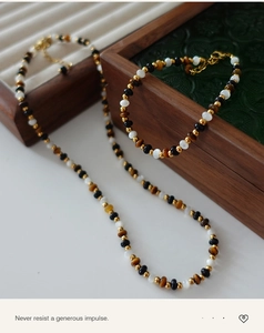 Detail of tiger eye bead necklace and bracelet set with gold spacers and lobster clasp